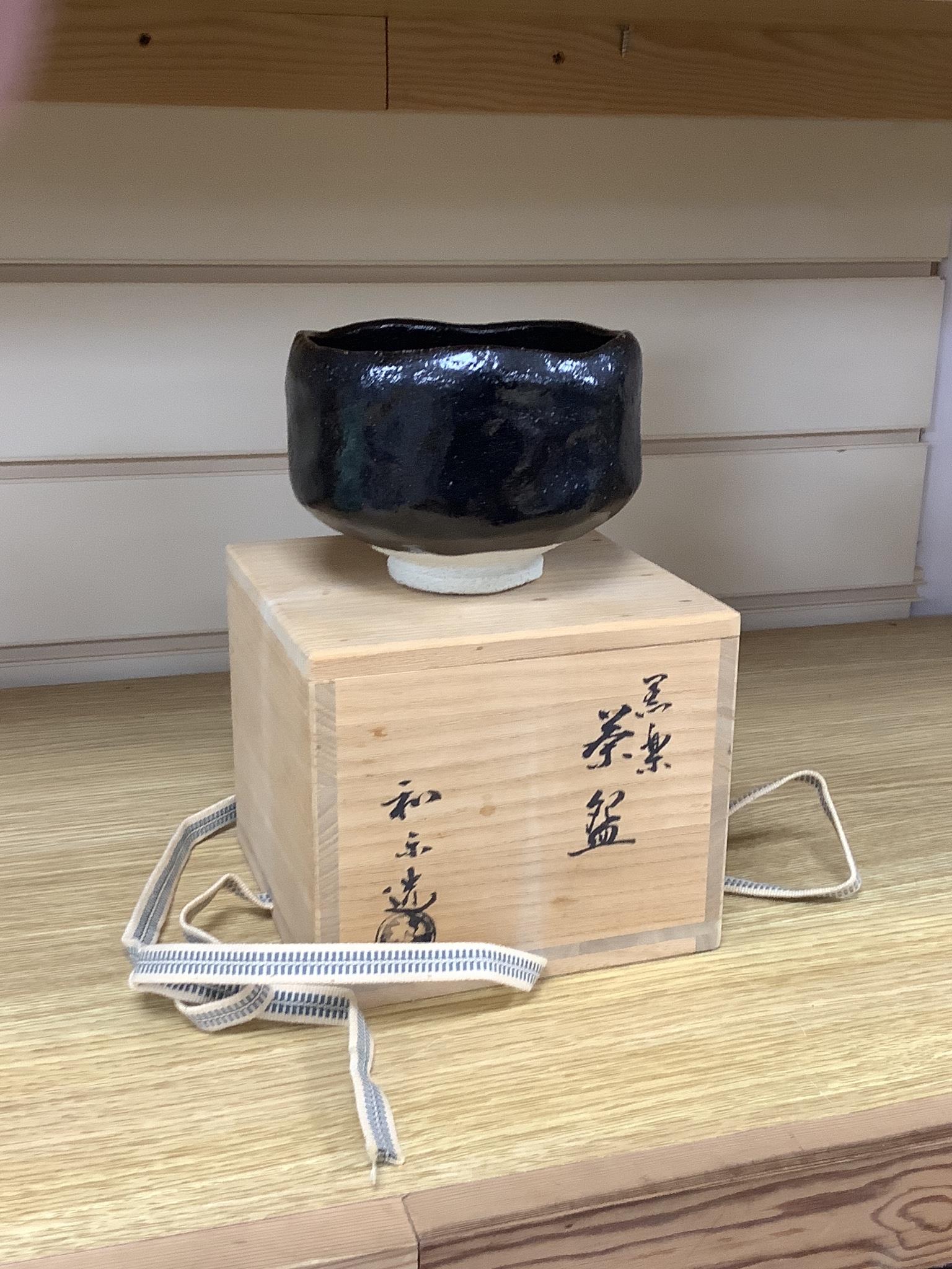 Japanese studio pottery: a boxed black glaze stoneware unomi tea bowl, with impressed mark, together with a ovoid vase, marked, 21cm tall